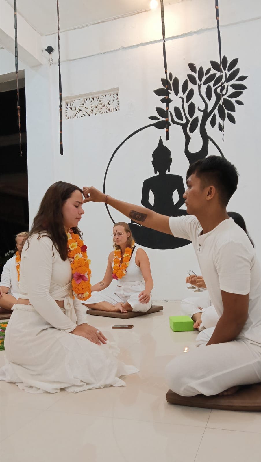 Boyana Vancheva receiving a tilaka blessing and a marigold garland at her yoga teacher training graduation ceremony in Bali